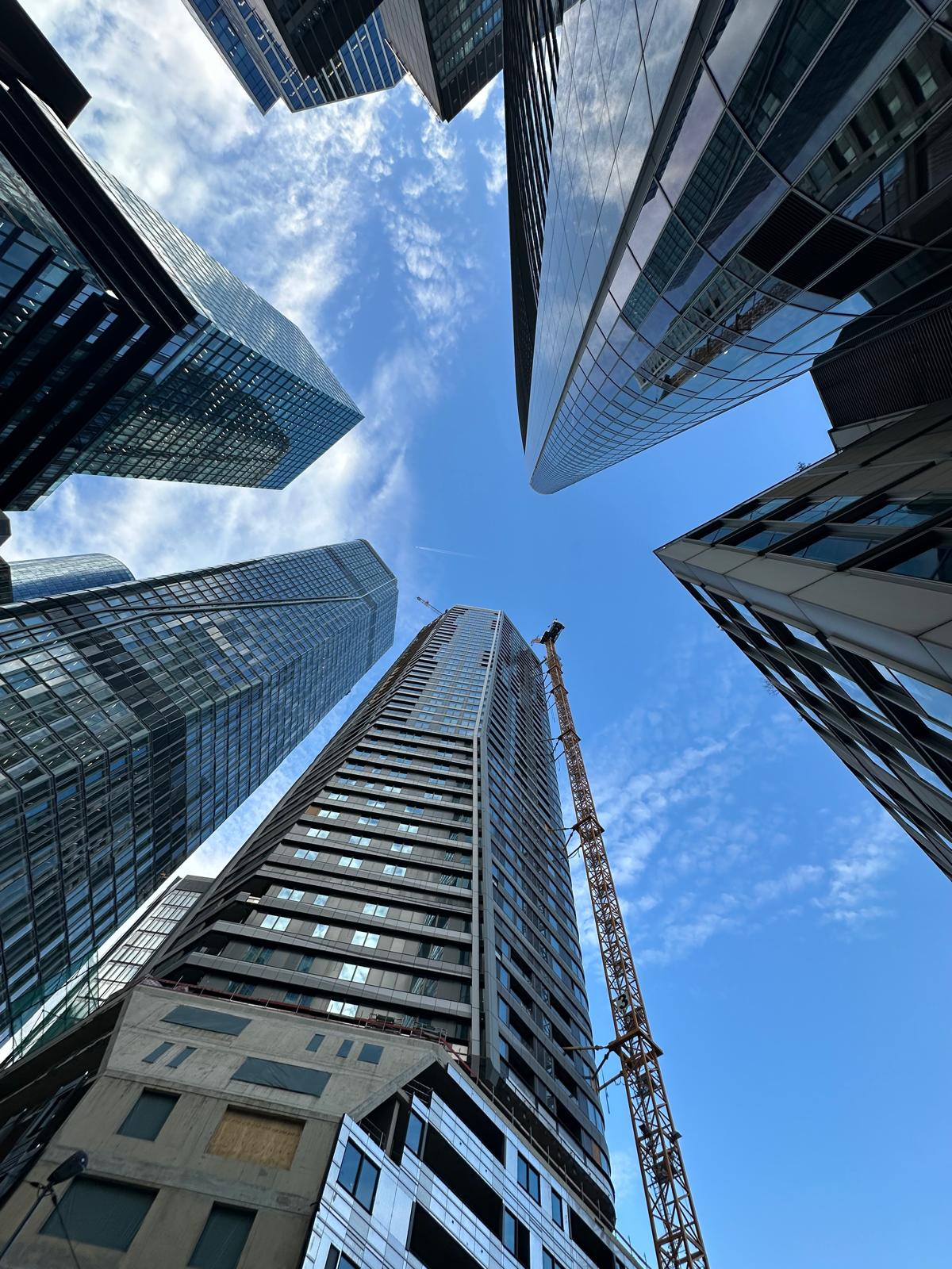 Modern high-rise buildings and a tower under construction photographed from below
